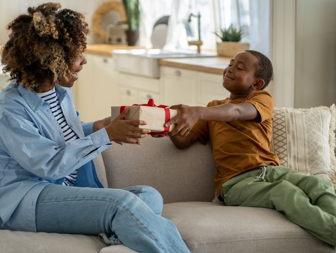 A child gives his mother a gift.