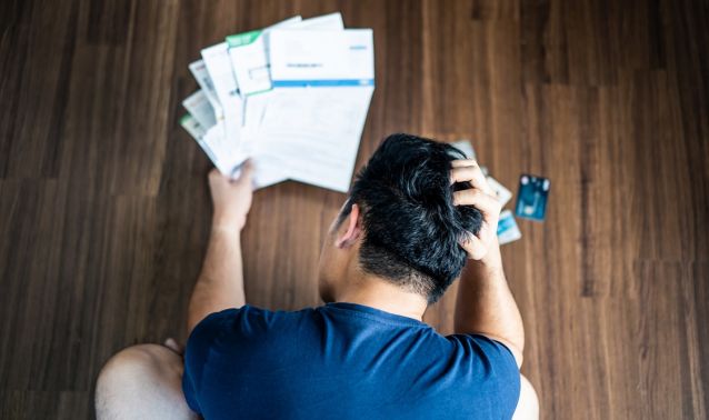 A man looks worringly at his bills