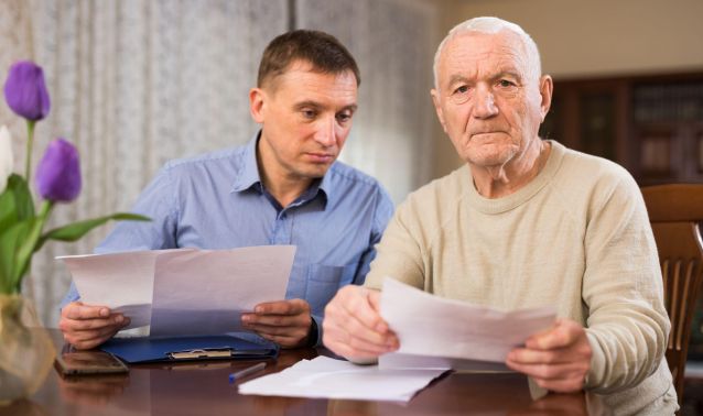 Two men reading over documents.