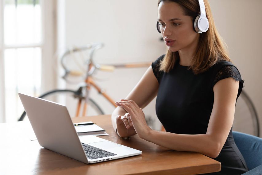 Young woman at laptop wearing headphones