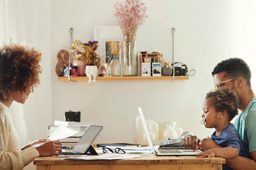 Young African American Family at the table with laptop, tablet, baby